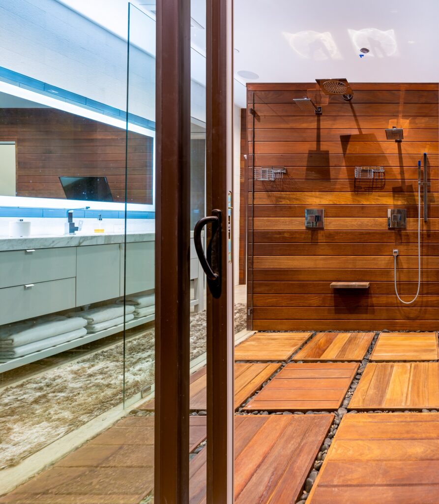 Large shower stall with wooden accents and exterior door